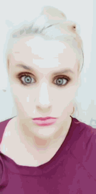 a woman with blonde hair and blue eyes is making a funny face