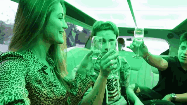a group of people are toasting with champagne in a limo