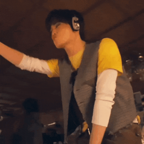 a man wearing a yellow shirt and brown pants is dancing in a room