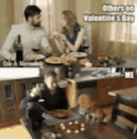 a man and a woman are sitting at a table with a child and a cat .