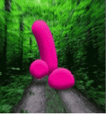 a pink penis is floating in the air in the middle of a forest .