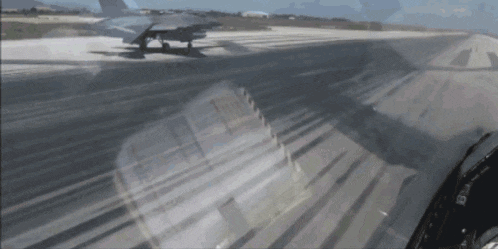 a plane is taking off from a runway with a reflection of a building in the background
