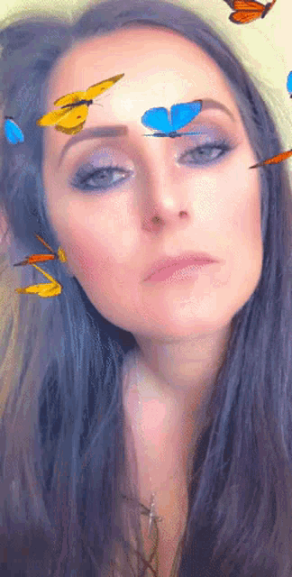a woman with butterflies flying around her face and a cross on her neck