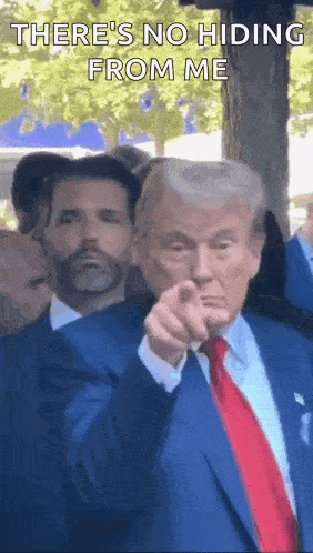 a man in a suit and tie is pointing at the camera and says `` there 's no hiding from me '' .