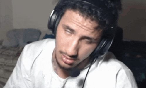 a man wearing headphones and a microphone is sitting at a table .