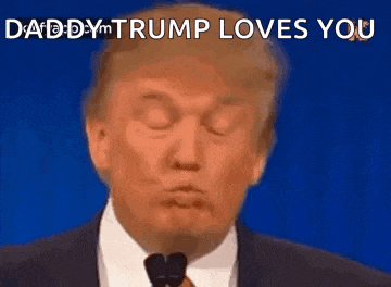 donald trump is wearing a suit and tie and making a funny face while talking into a microphone .