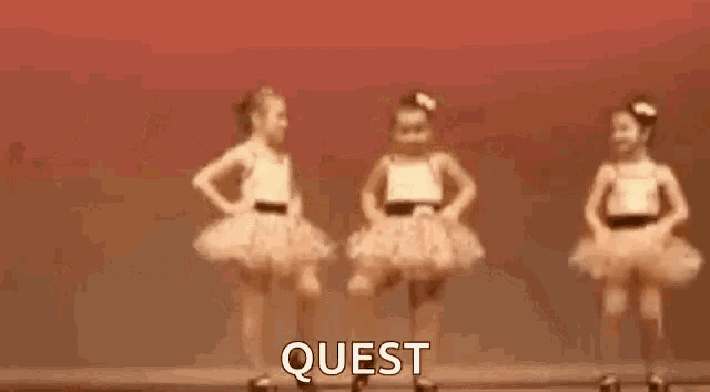 two little girls in tutus are dancing on a stage and the word quest is on the bottom .