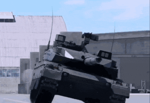 a military tank is driving down a road