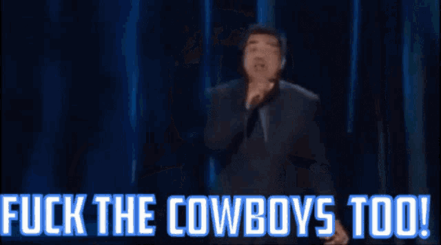 a man singing into a microphone with the words " fuck the cowboys too " below him