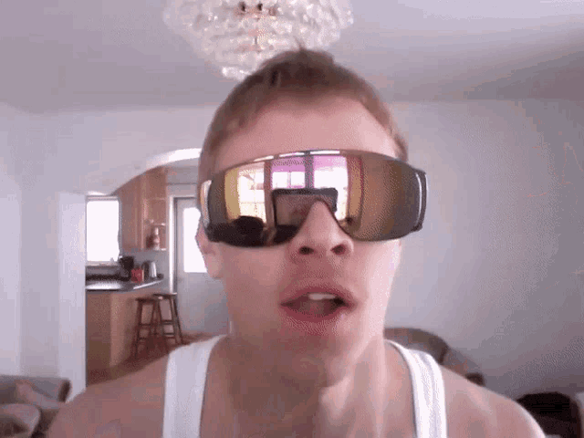 a man wearing sunglasses is making a face
