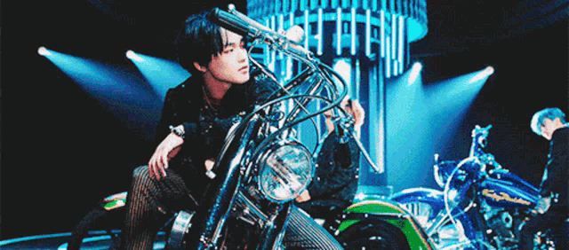 a man is sitting on a motorcycle in front of a crowd