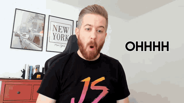 a man with a beard wearing a black shirt that says js