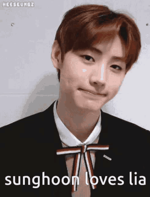 a young man wearing a suit and bow tie is smiling and says sunghoon loves lia .