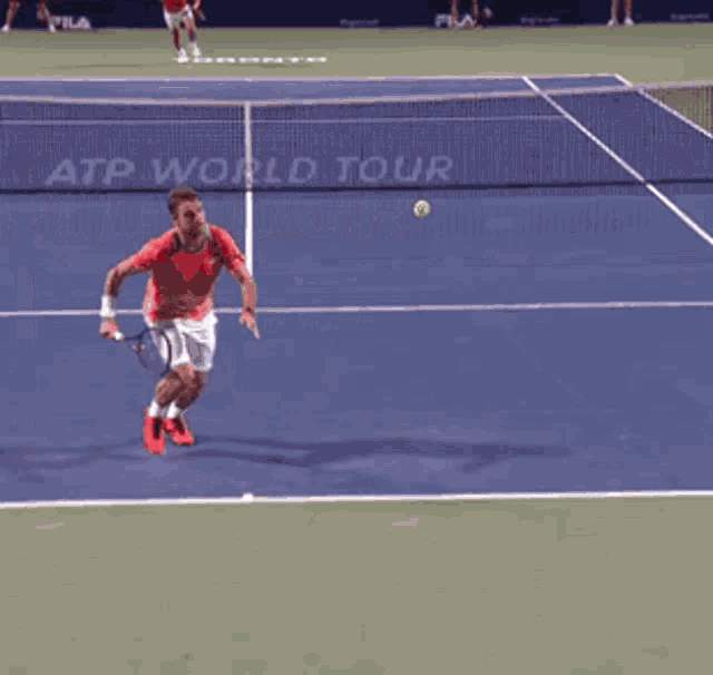 a man in a red shirt is serving a tennis ball on a tennis court that says toronto