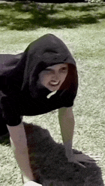 a woman in a black hoodie is doing push ups