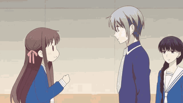 a boy and two girls are standing next to each other and talking