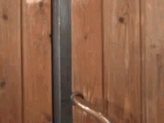 a woman in a red sweater is standing in a doorway looking out .