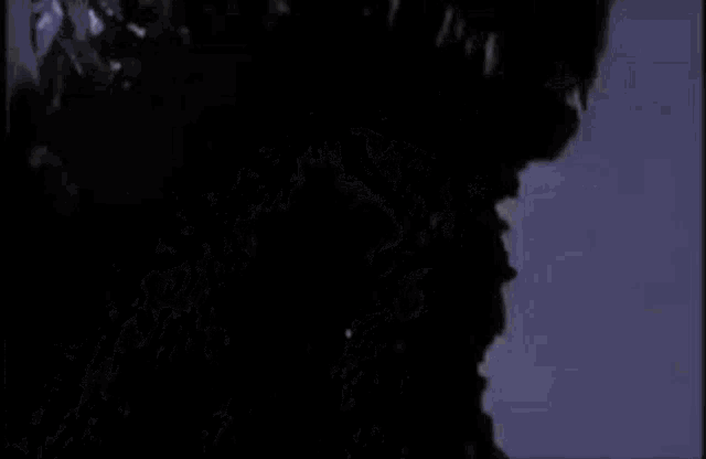 a close up of a monster 's head with a purple background .