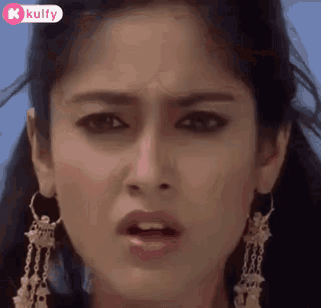a close up of a woman 's face with a shocked look on her face .
