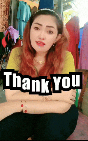 a woman sitting in front of a sign that says ' thank you '