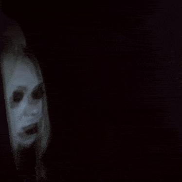 a woman with long blonde hair and black eyes is standing in front of a mirror
