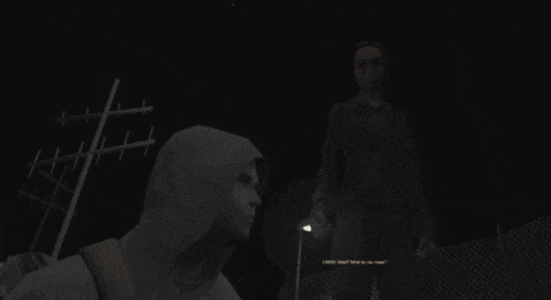 a man in a hooded sweatshirt stands next to another man in a dark room