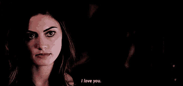 a woman is talking to a man in a dark room and saying `` i love you '' .