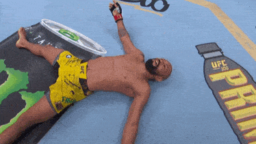 a fighter laying on the floor with a ufc 300 advertisement in the background