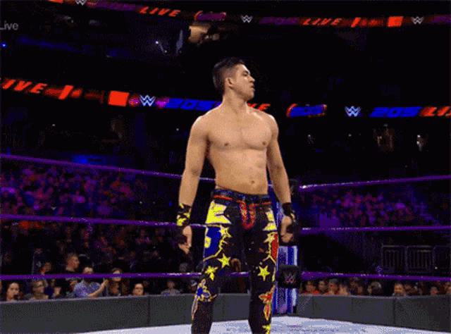 a shirtless wrestler in a ring with a referee