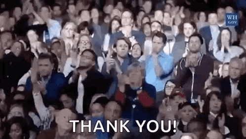 a large group of people are applauding and saying thank you .