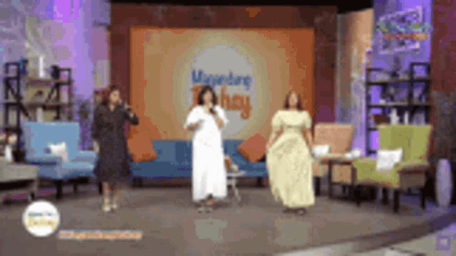 a woman in a white dress is dancing on a stage in front of a couch and chairs .
