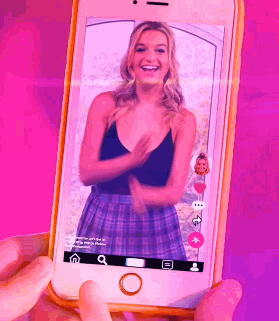 a woman in a plaid skirt is on a cell phone screen