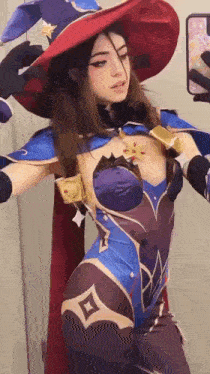 a woman in a witch costume is taking a selfie with her cell phone .