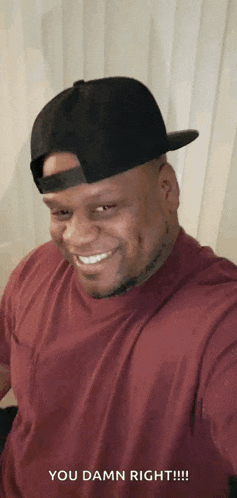 a man wearing a baseball cap and a red shirt is smiling and taking a selfie .