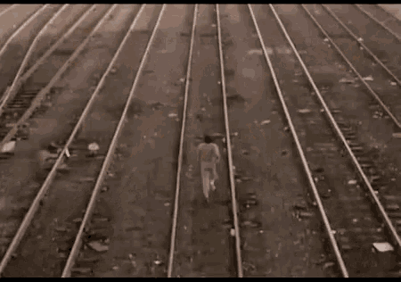 a person walking along train tracks with the word lari in yellow letters