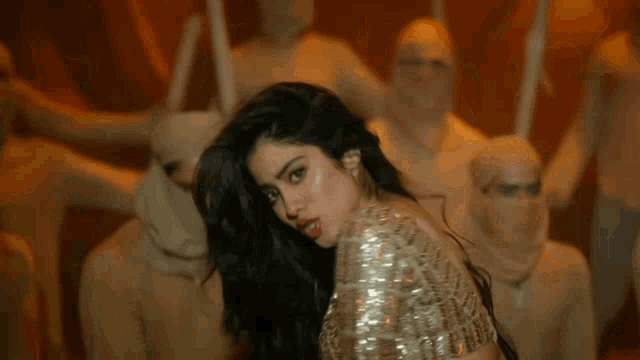 a woman is dancing in front of a crowd of people .