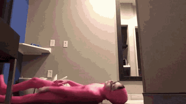 a person in a pink suit laying on the floor