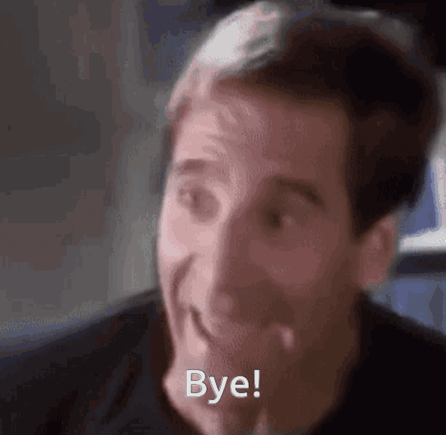 a man is smiling and saying bye with his hand on his chin .