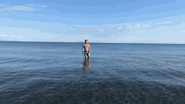 a man stands in the middle of a body of water