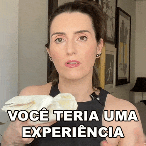 a woman in a black tank top is holding a piece of paper that says você teria uma experiencia