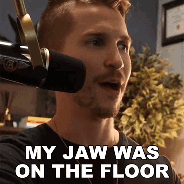 a man speaking into a microphone with the words " my jaw was on the floor " next to him