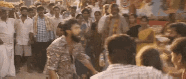 a man is standing in front of a crowd of people .
