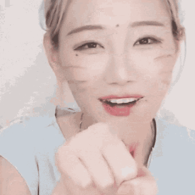 a close up of a woman 's face with her finger pointing
