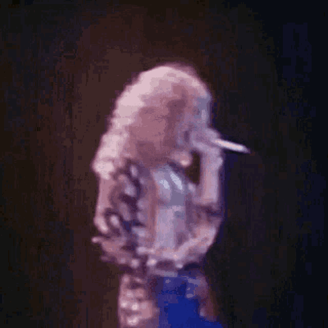 a close up of a man singing into a microphone on a stage .