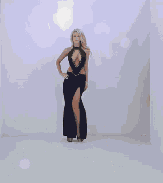 a woman in a long black dress with a high slit