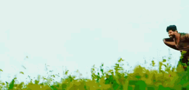 a man is flying through the air in a field of grass .