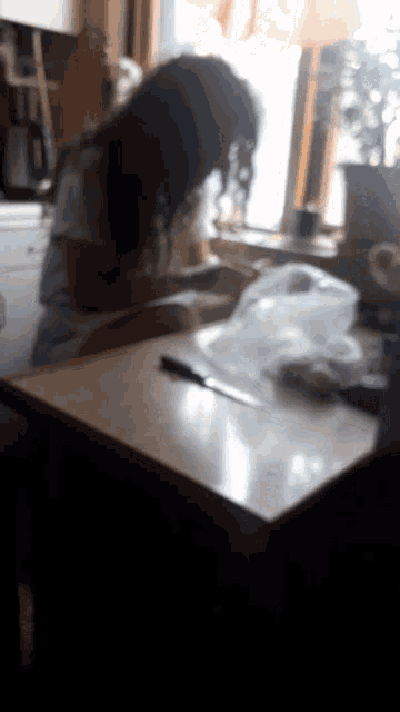 a blurry picture of a woman sitting at a table