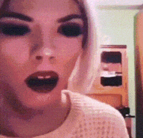 a close up of a woman 's face with black eyes