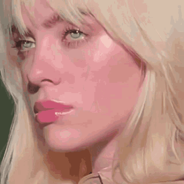 a close up of a woman 's face with a pink lip .