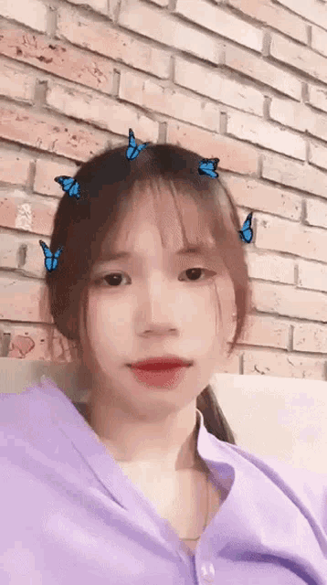 a girl wearing a purple shirt with butterflies on her head
